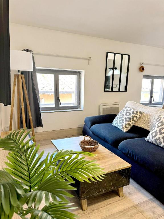 un salon avec un canapé bleu et une table dans l'établissement Narbonne centre Nid douillet Via Domitia, à Narbonne