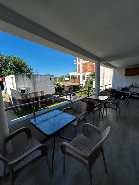 a balcony with tables and chairs and a large window at Apartmani Musić in Ulcinj