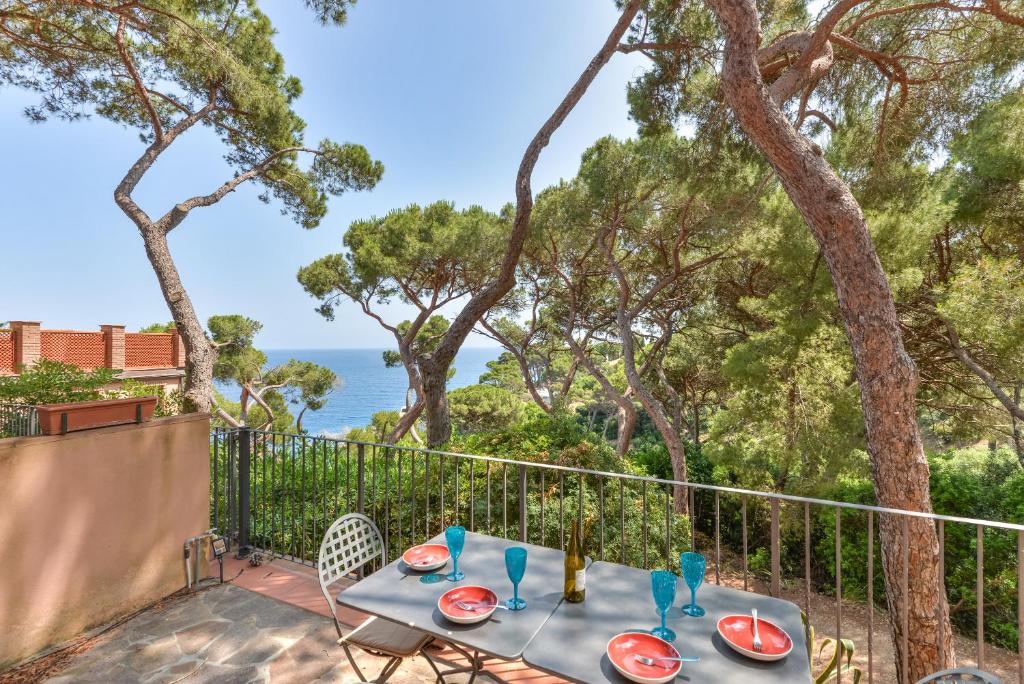 Una mesa en un balcón con vista al mar. en Appartamento Capo d'Arco Margherita, en Capo D'Arco