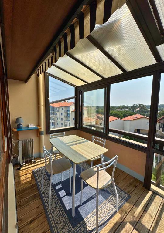 une table et des chaises sur un balcon avec vue dans l'établissement SABORDS - Studio au port de Capbreton, à Capbreton