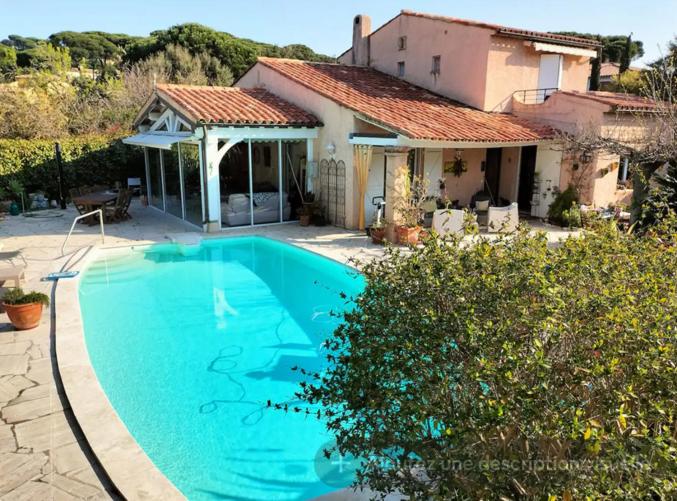 une grande piscine bleue devant une maison dans l'établissement charmante villa 6 pers au calme, à Sainte-Maxime