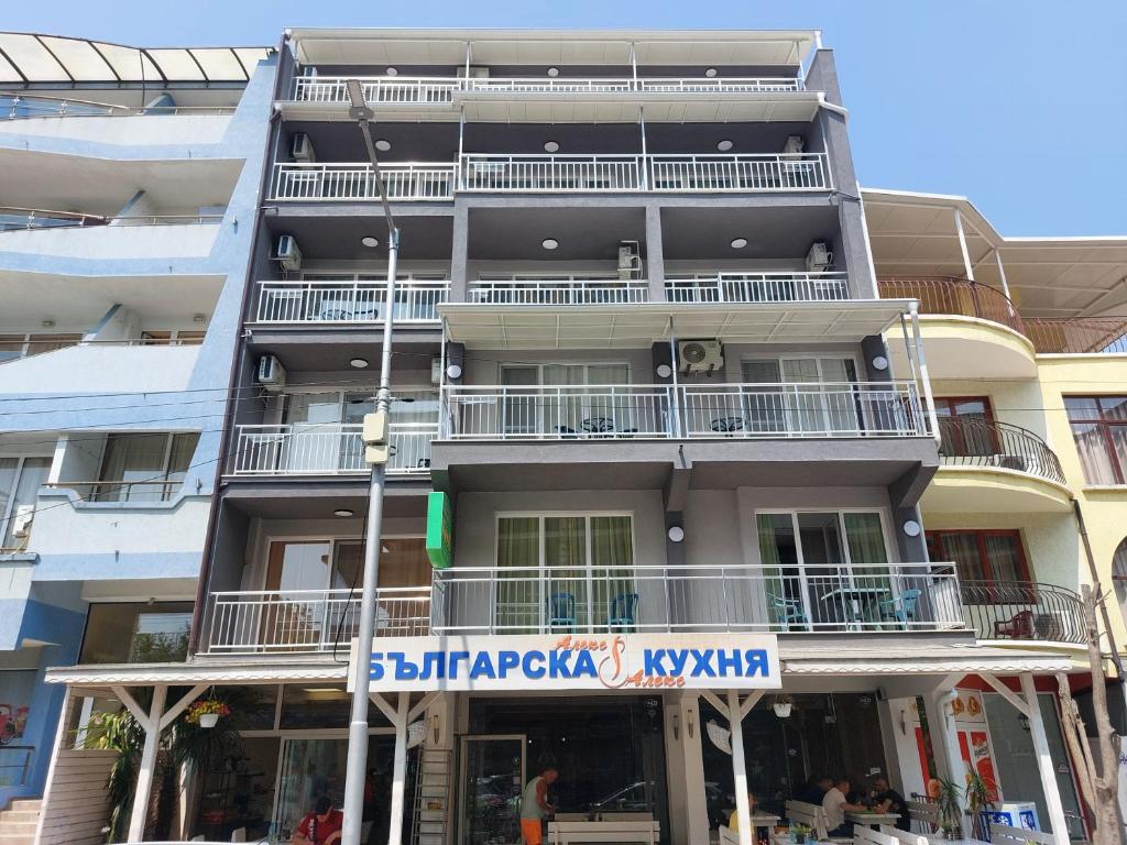 an apartment building with a sign in front of it at Guest house WEST in Sunny Beach