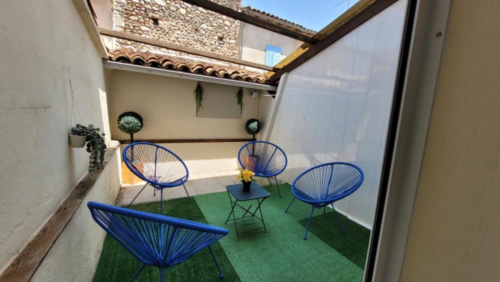 un groupe de chaises et de tables sur un balcon dans l'établissement Maison de village avec patio, à Bonnac