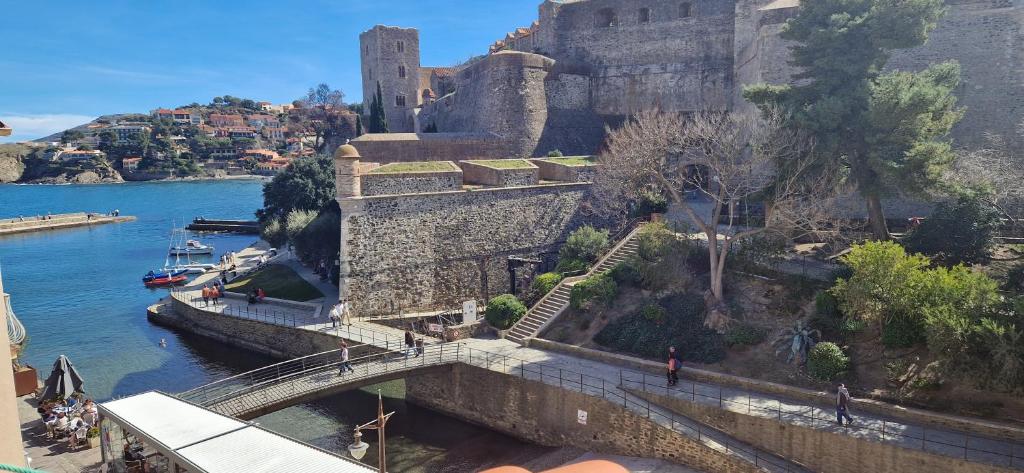 un pont sur une rivière à côté d'un château dans l'établissement La maison du pêcheur, à Collioure