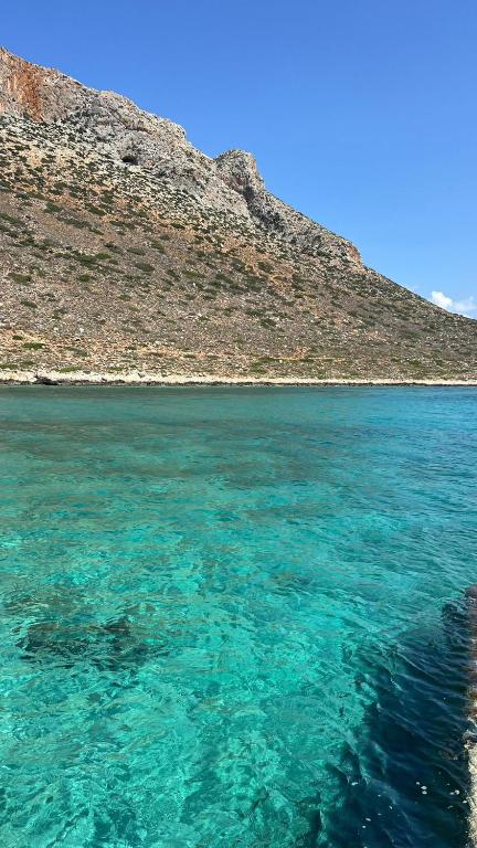 a large body of blue water next to a hill at MIRA MARE - Apartment 5 in Stavros