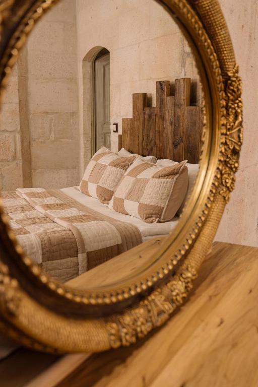 a mirror reflection of a bed in a bedroom at Cappadocia Cave Suites Adult Only in Goreme