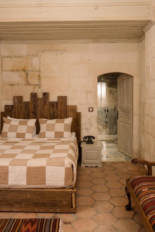a bedroom with a large bed and a walk in shower at Cappadocia Cave Suites Adult Only in Goreme