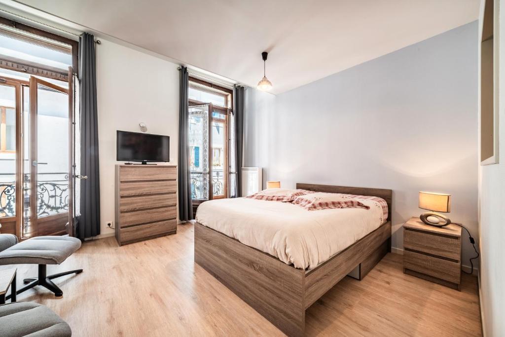 une chambre avec un lit et une télévision à écran plat dans l'établissement Le Central Evian, à Évian-les-Bains