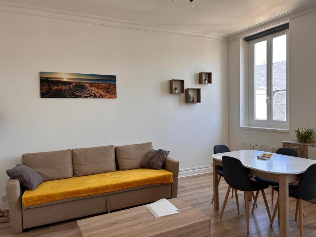 un salon avec un canapé et une table dans l'établissement L'embrun Fécampois, à Fécamp