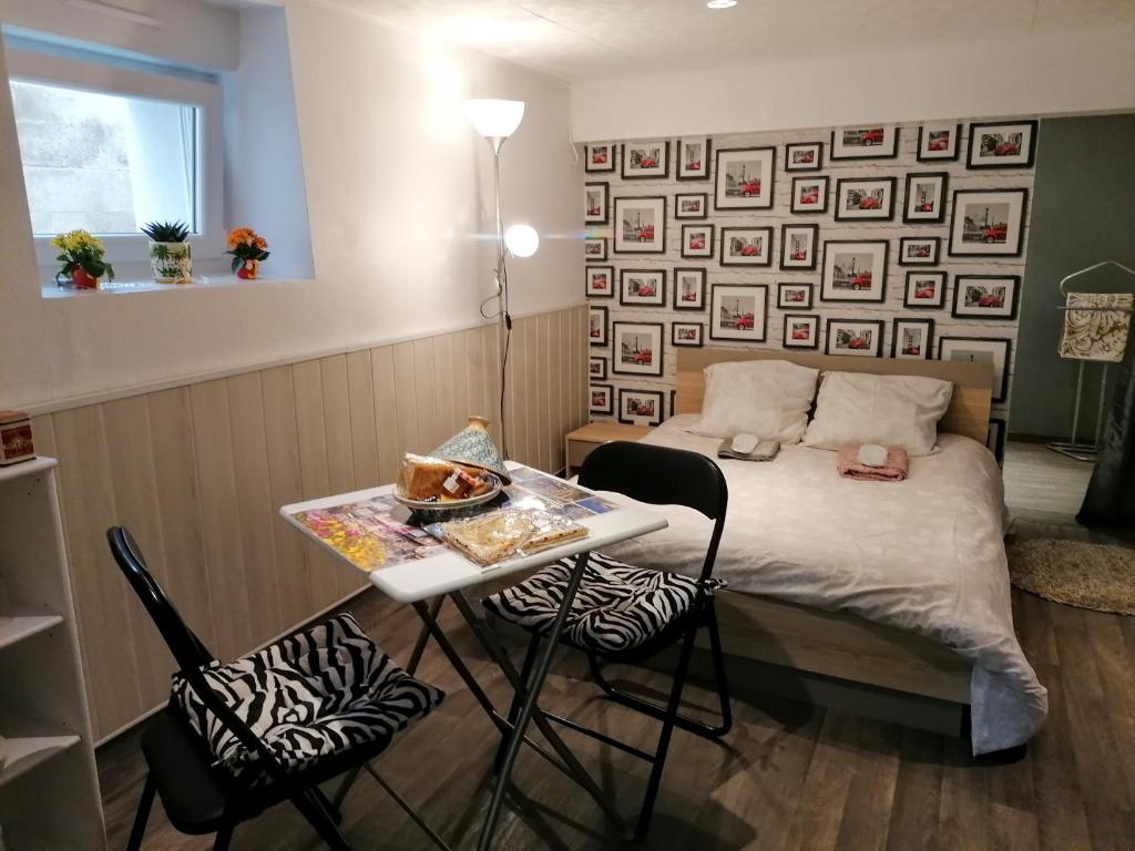 une chambre avec un lit et une table avec des chaises dans l'établissement Guest house dans jardin exotique, quartier calme, jacuzzi, parking gratuit, à Morlaix