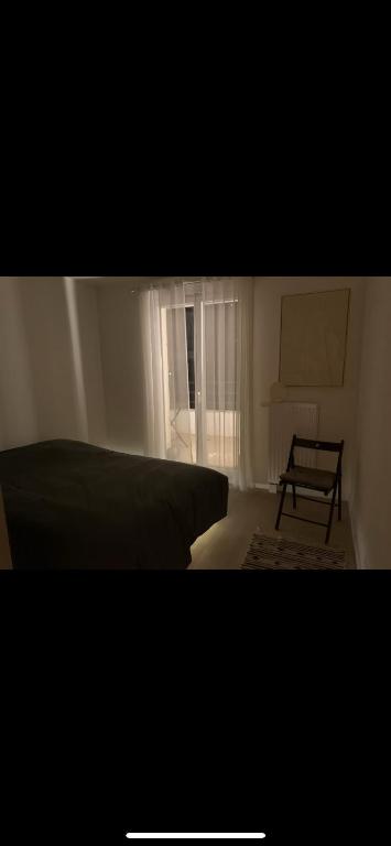 une chambre avec un lit et une fenêtre dans l'établissement Puteaux-La Défense, appartement haut standing, à Puteaux
