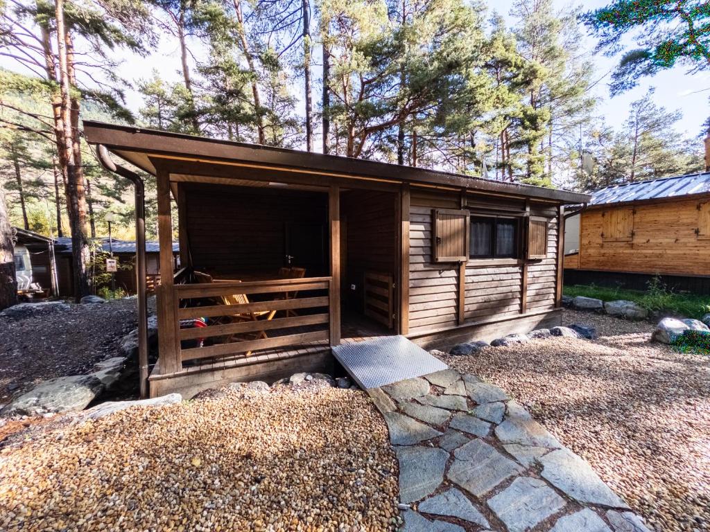 a wooden cabin with a large window in a yard at Campeggio Beaulard in Beaulard