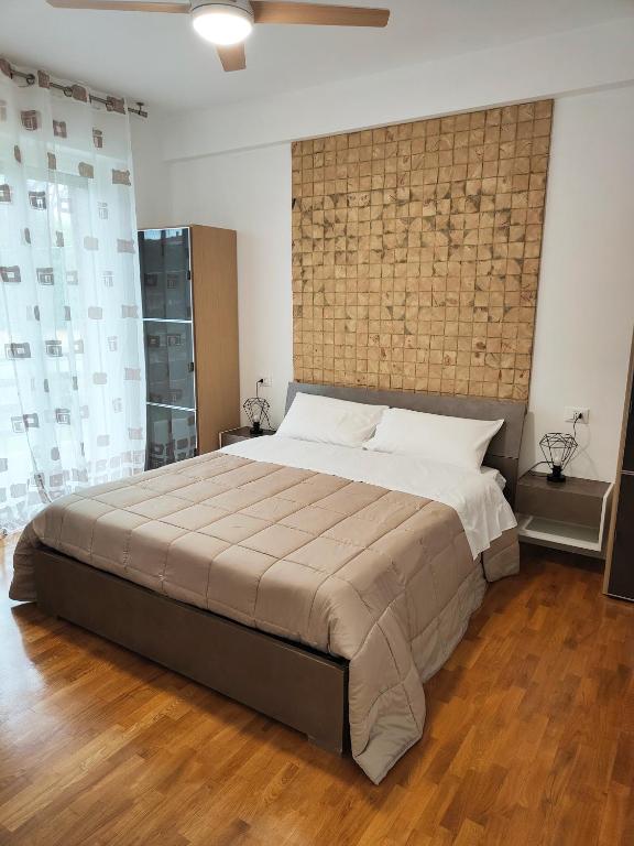 a bedroom with a large bed with a brick wall at Bastia Home Plus in Bastia Umbra