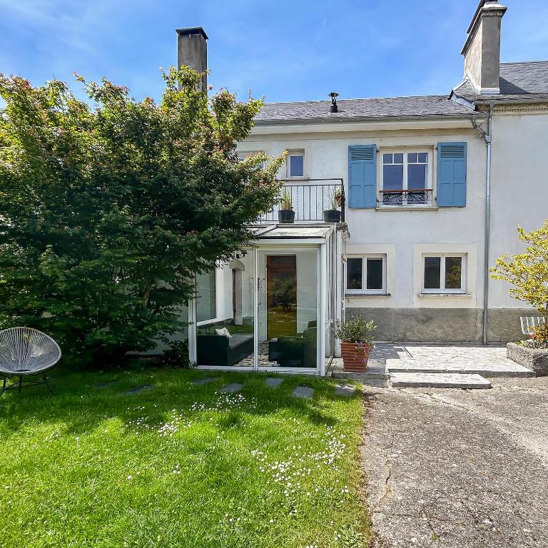 une grande maison blanche avec une porte en verre dans l'établissement Séjour champêtre à la ferme près de Pau, à La Celle-sous-Gouzon