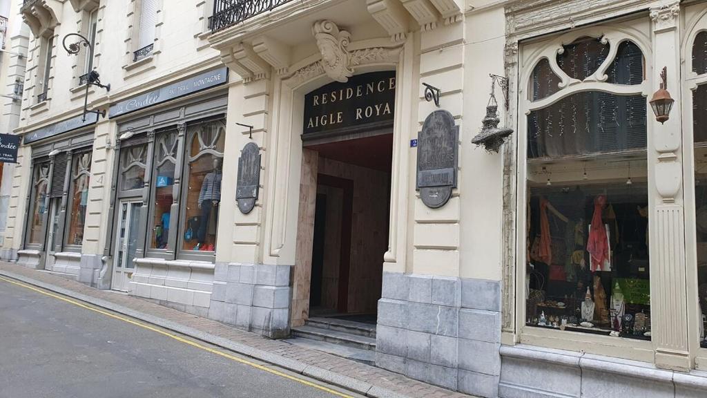 un bâtiment situé sur le côté d'une rue avec des magasins dans l'établissement Appartement rénové en plein coeur de Cauterets, à Cauterets