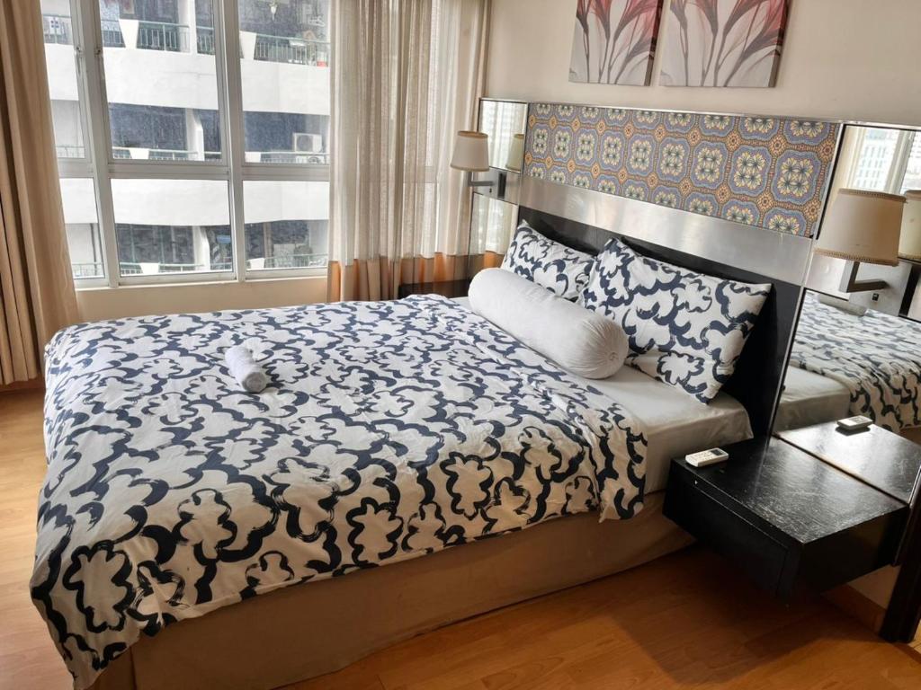 a bedroom with a large bed and a window at Seri Bukit Ceylon Bukit Bintang in Kuala Lumpur