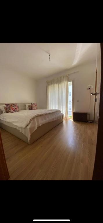 une chambre avec un grand lit et un parquet dans l'établissement Appartement cosy, à Perpignan