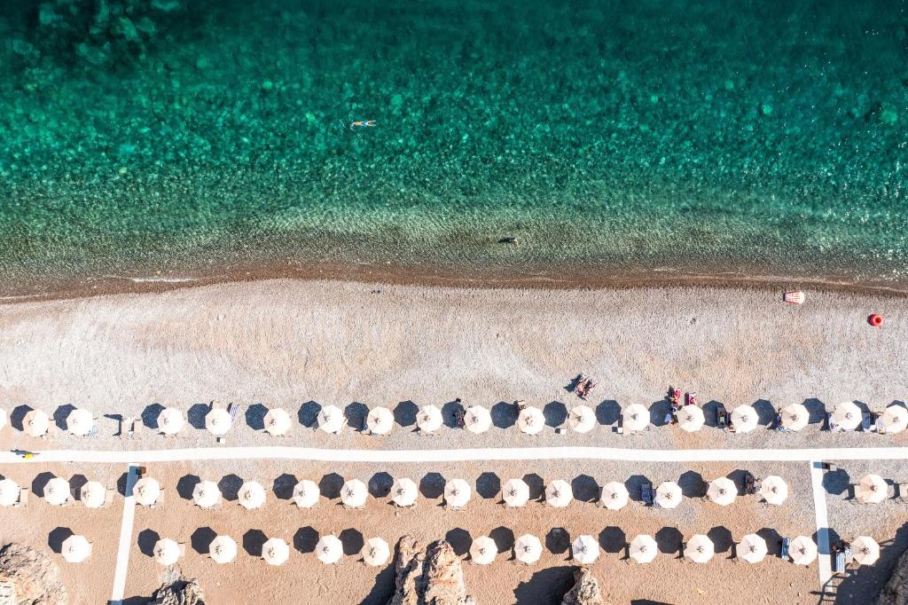 an overhead view of a beach with umbrellas and the ocean at The Chedi Luštica Bay in Tivat