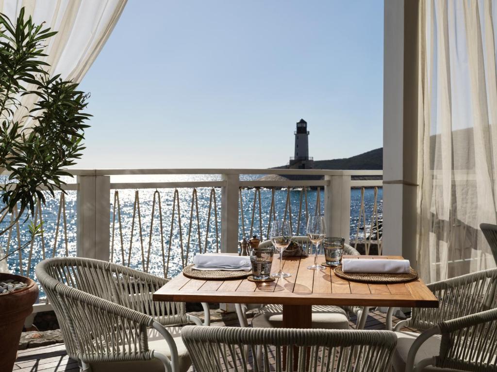 a table on a balcony with a view of the ocean at The Chedi Luštica Bay in Tivat