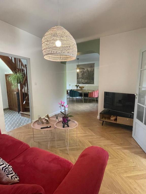 un salon avec un canapé rouge et une télévision dans l'établissement Lou Castelet maison de charme climatisée Centre ville Albi, à Albi