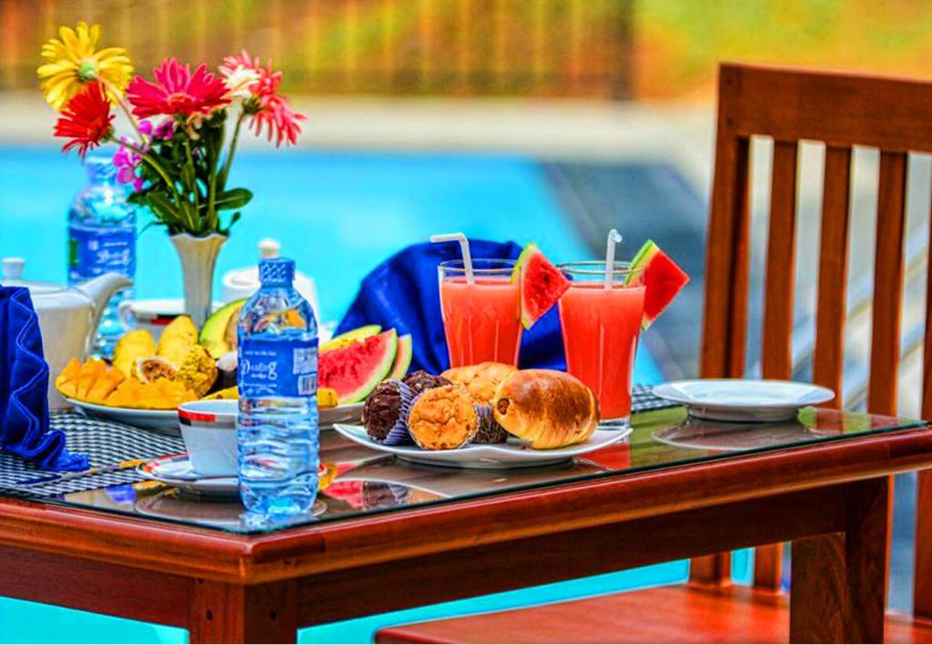 a table with plates of food and drinks on it at Grand Hills kandy in Kandy