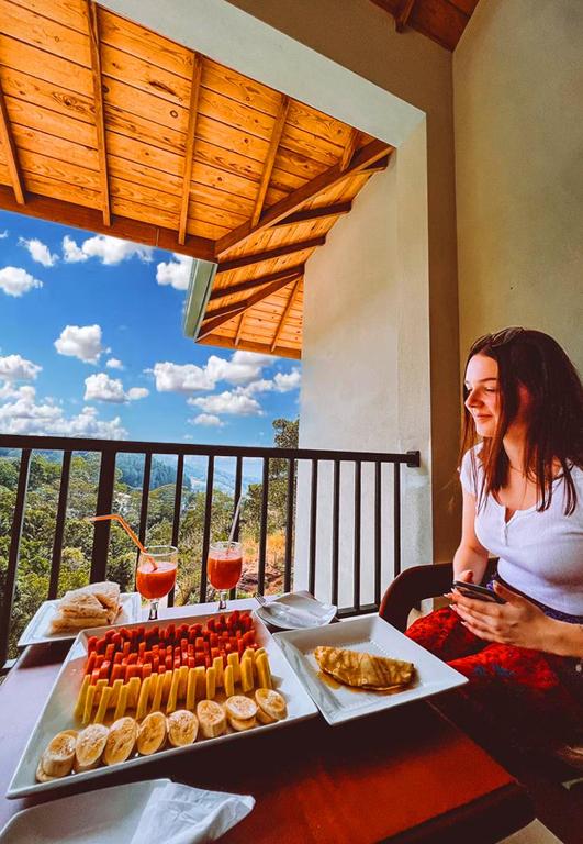 a woman sitting at a table with a tray of food at Grand Hills kandy in Kandy