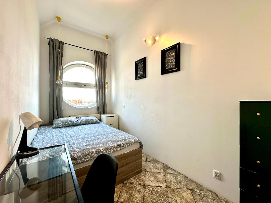 a small bedroom with a bed and a window at Pokoje Monte 49 in Sopot