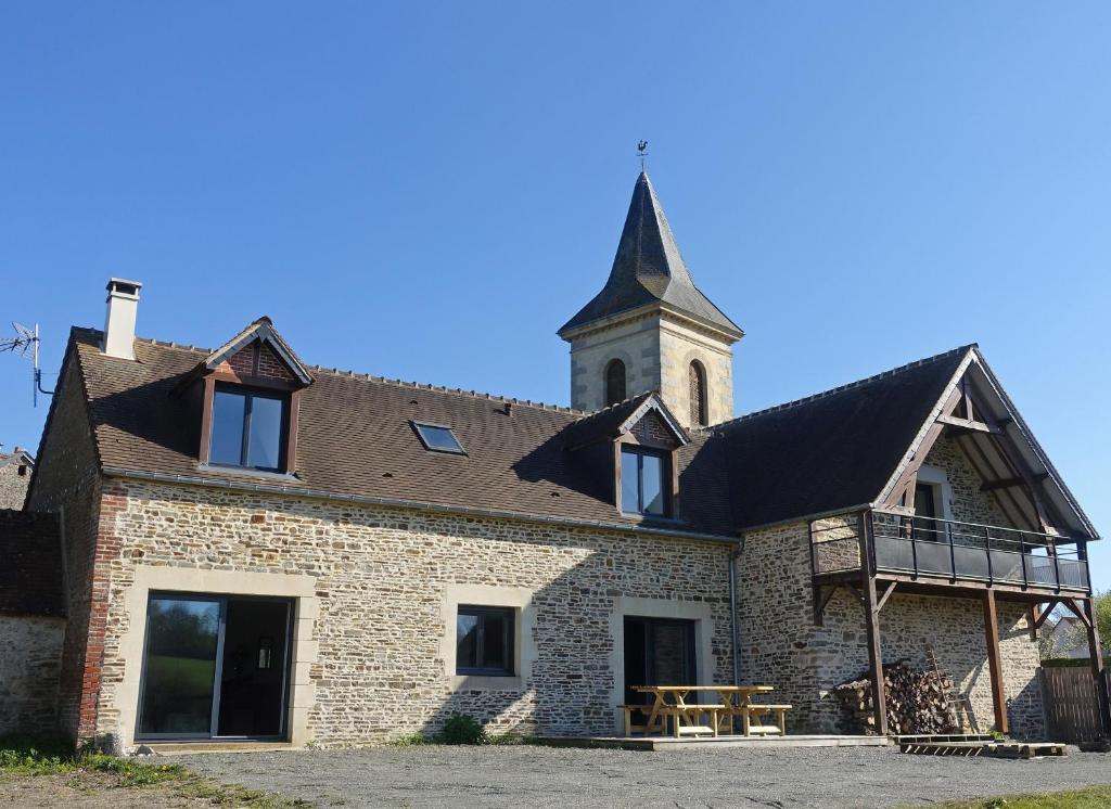 un grand bâtiment en briques avec une tour d'horloge dans l'établissement Le Minerai, à Mortrée