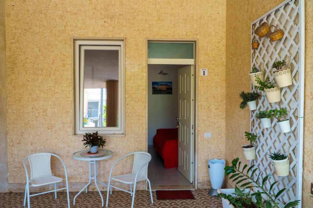 a patio with a table and chairs and a mirror at Boulevard Holiday in Avola