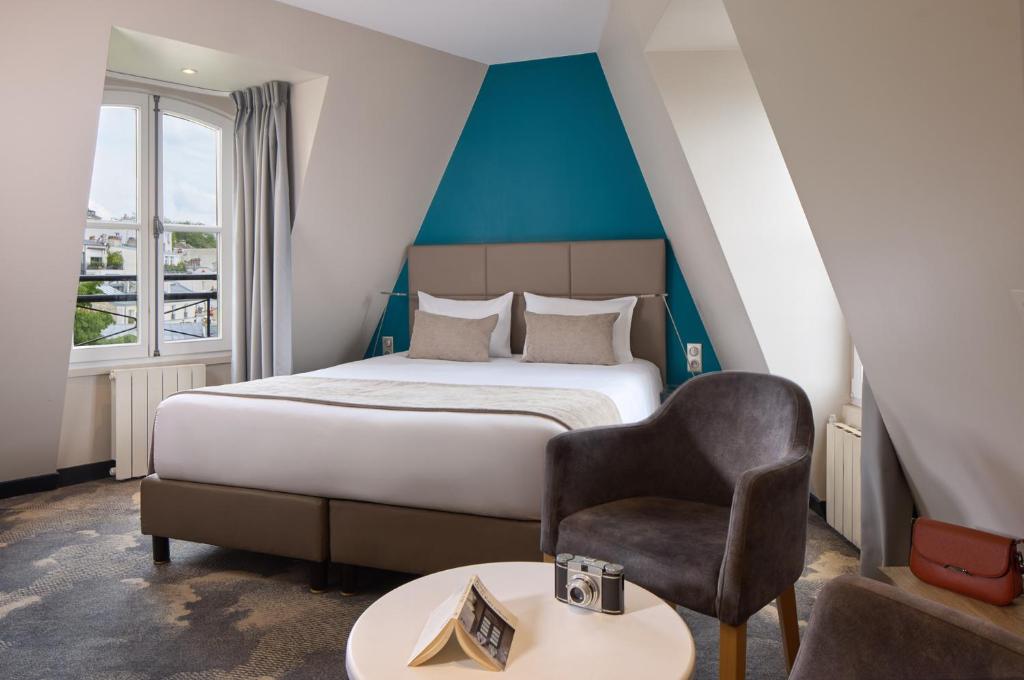 a bedroom with a bed and a chair and a table at Timhotel Montmartre in Paris