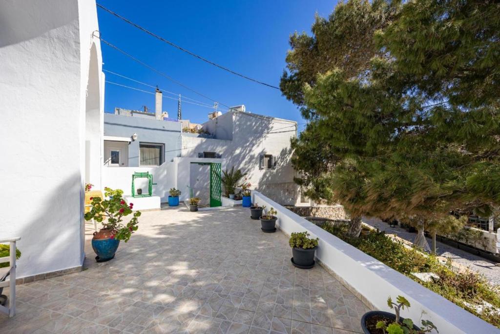 a walkway with potted plants on the side of a building at Amoni House- An authentic village stay in Pyrgos