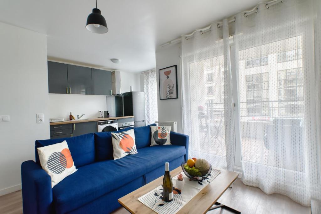 un salon avec un canapé bleu et une table dans l'établissement Appartement Chic, à Saint-Ouen