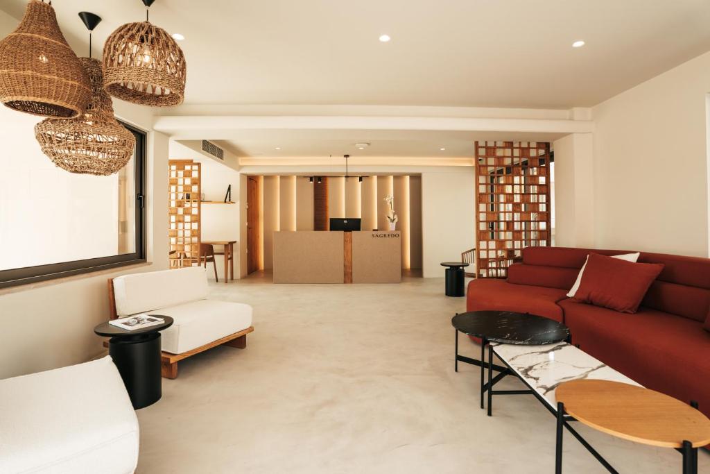 a living room with a red couch and chairs at Sagredo Boutique Hotel & Spa in Ágios Fokás