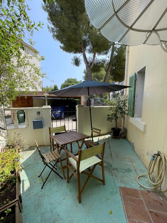 une table et des chaises avec un parasol sur une terrasse dans l'établissement Modern house with terrace and parking in Toulon, à Toulon