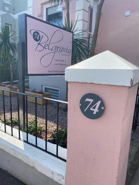 a pink trash can sitting in front of a fence at 74Belgravia in Torquay