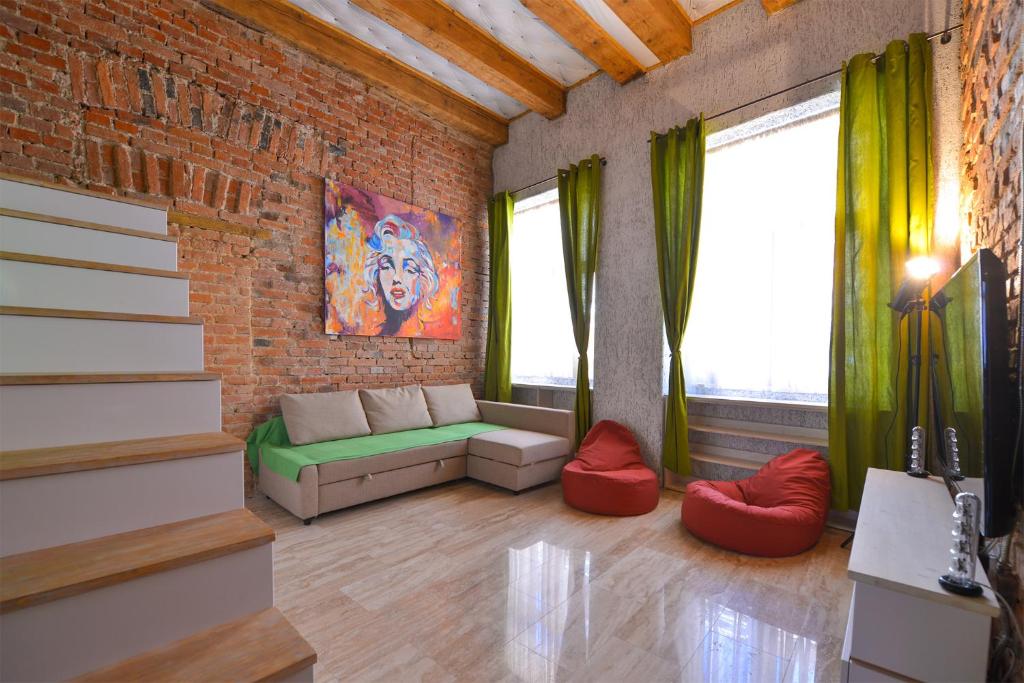 a living room with a couch and a brick wall at Michael Weiss apartment in Braşov
