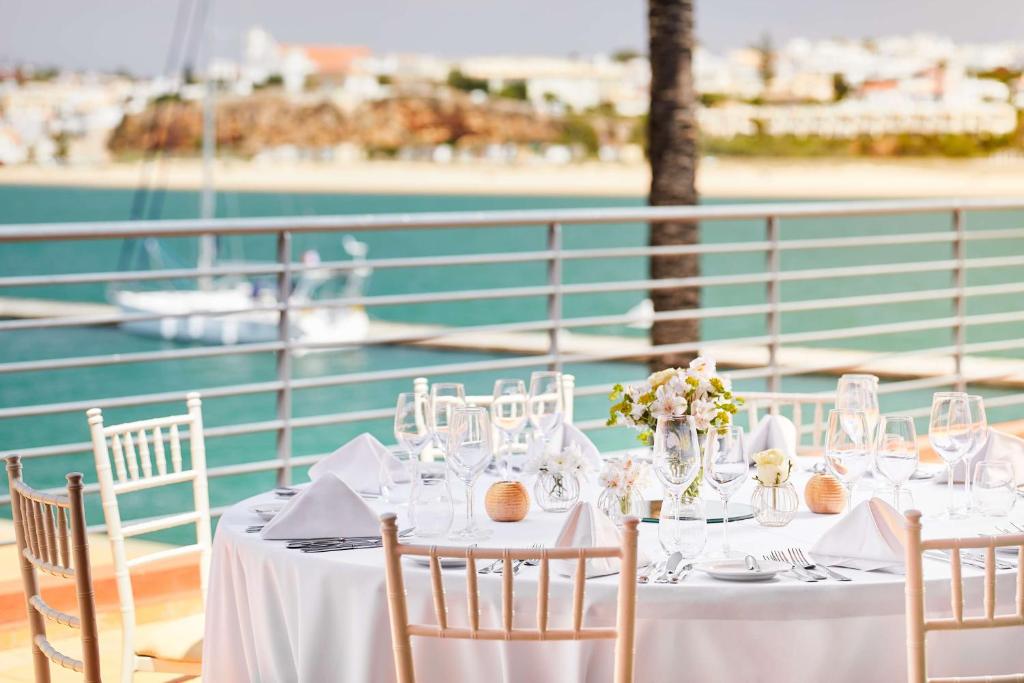 a table with chairs and wine glasses on a boat at NH Marina Portimao Resort in Portimão