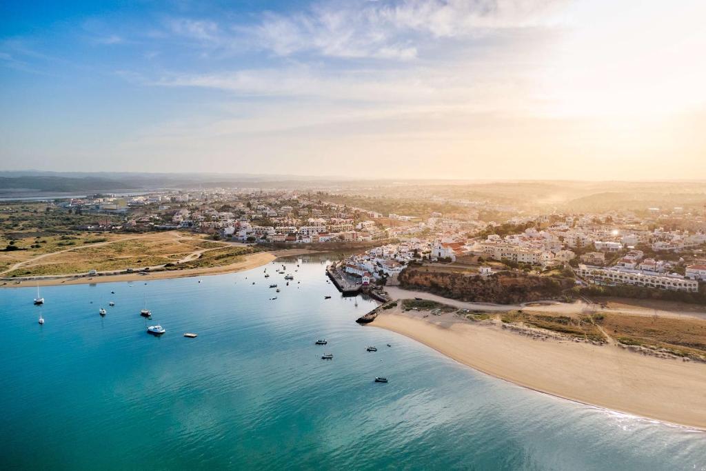 an aerial view of a beach with boats in the water at NH Marina Portimao Resort in Portimão