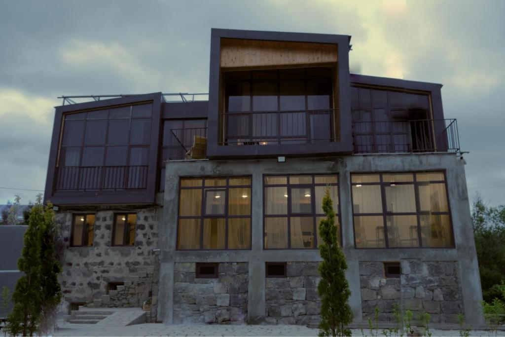 a house with large windows and a balcony at Beeography guest house in Vardablur