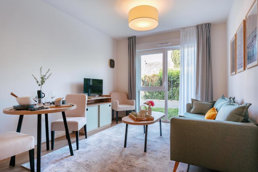 un salon avec un canapé et une table dans l'établissement Zenitude Hôtel-Résidences Ploërmel, à Ploërmel