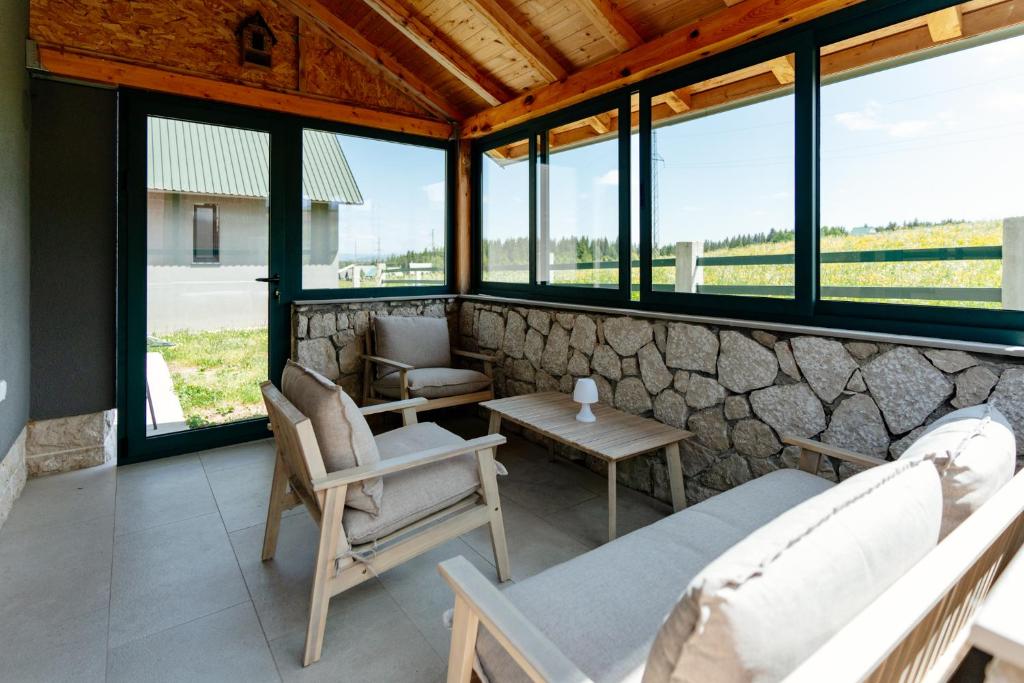 una stanza con sedie, tavolo e finestre di Villa Dussi a Žabljak
