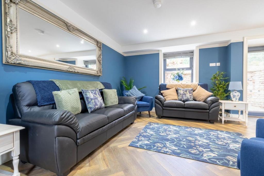 a living room with a couch and a mirror at Boutique Stays at 56B in Newtownards