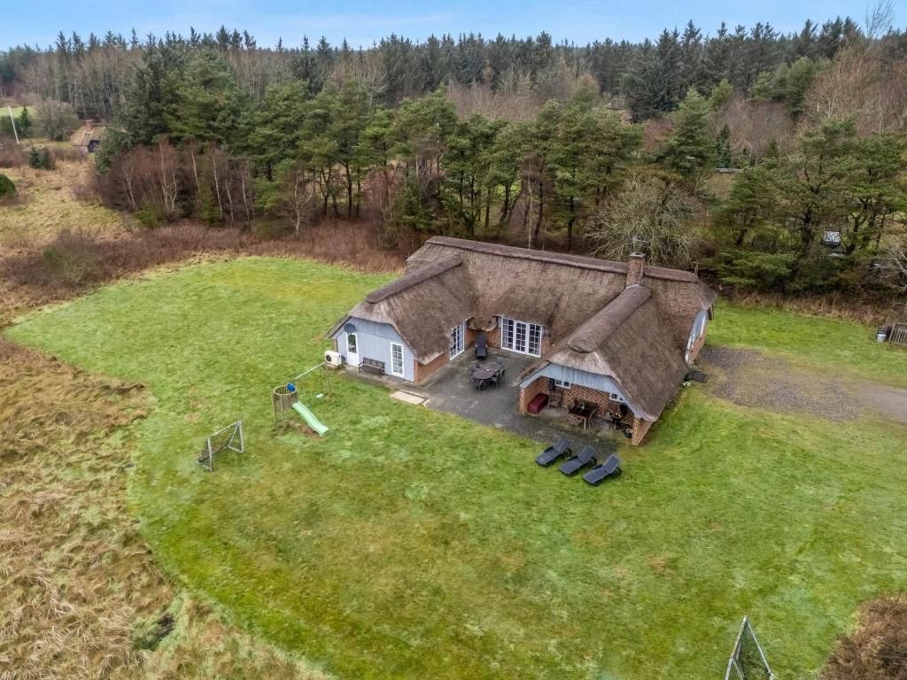 an aerial view of a house on a grass field at Large Holiday Home With Pool, Spa And Sauna, 1500 Meters From The North Sea in Ulfborg