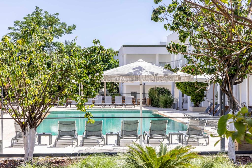 a swimming pool with chairs and a table and umbrella at Costa Maya Bodrum in Bodrum City