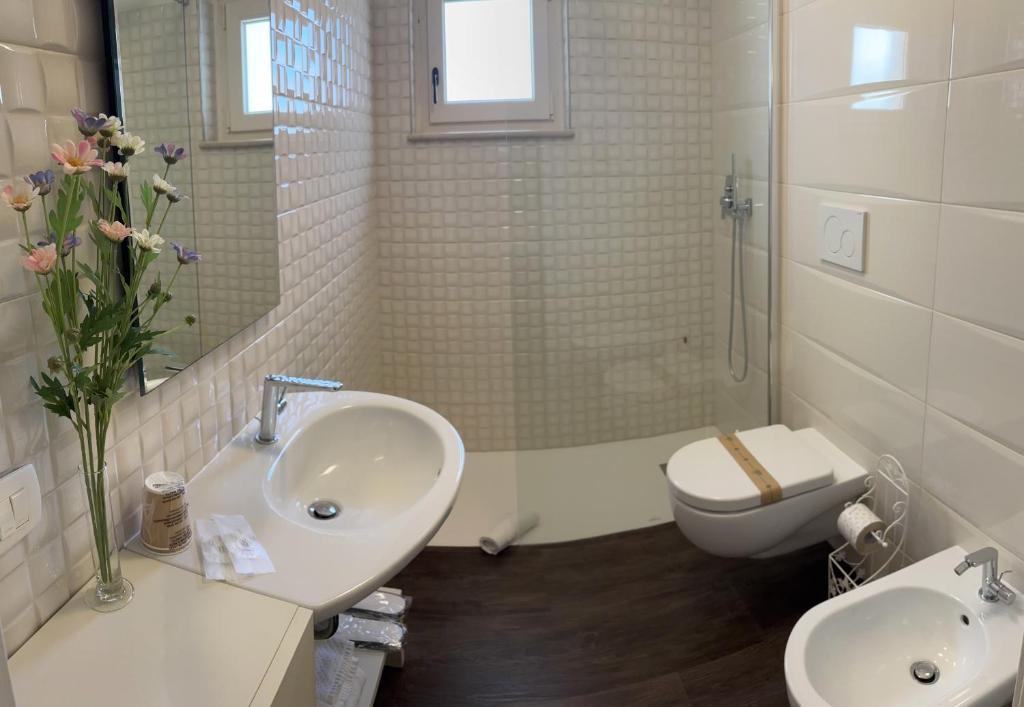 une salle de bain blanche avec un lavabo et des toilettes dans l'établissement La Cummersa Trulli Holiday, à Alberobello 10 autres photos