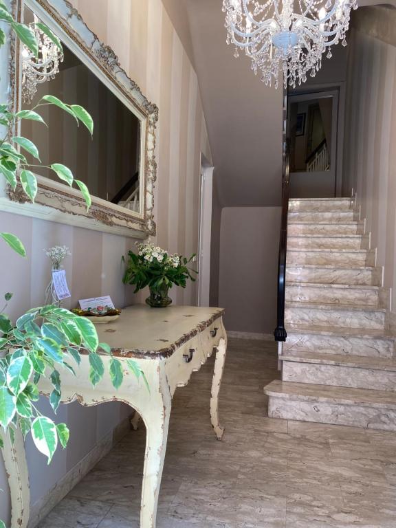 una stanza con tavolo, specchio e scale di Castello a San Benedetto del Tronto