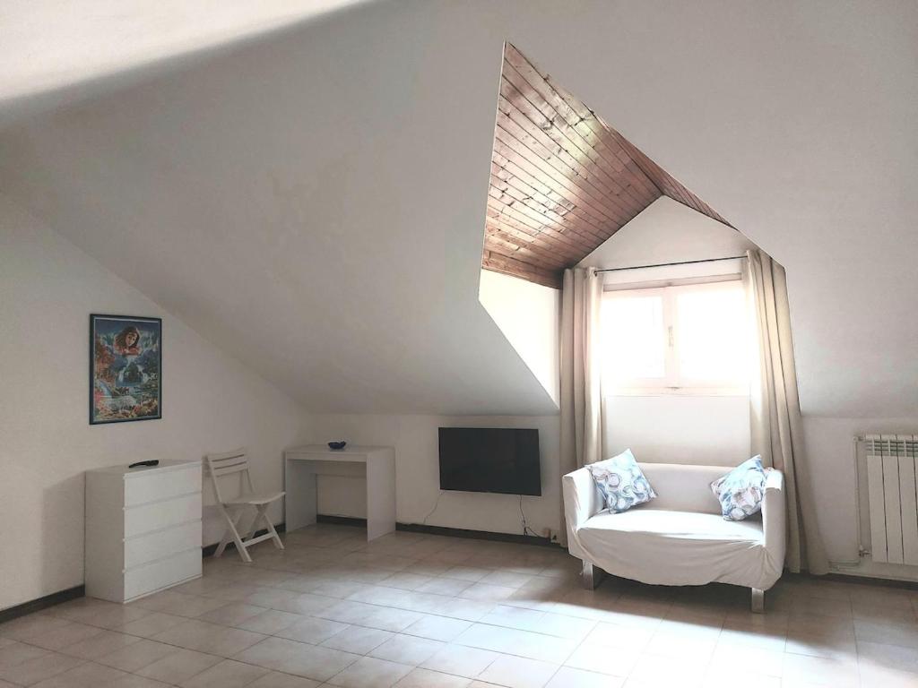 a living room with a white couch and a window at La Brezza di lago in Baveno