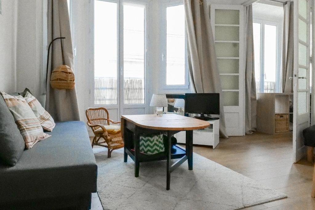 una sala de estar con una mesa y un sofá en Appartement charmant hyper centre, en Les Sables-dʼOlonne