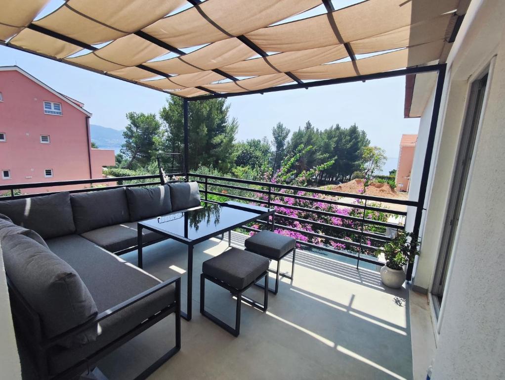 eine Terrasse mit einer Couch und einem Tisch auf einem Balkon in der Unterkunft Apartment FortyTwo in Orebić
