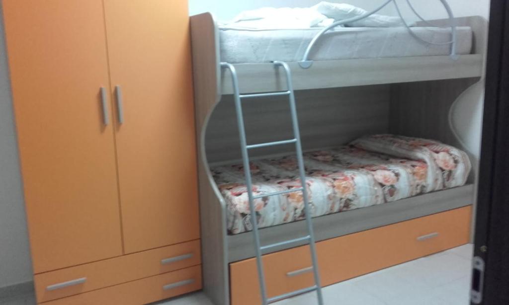 a bunk bed with a ladder next to a cabinet at Casa Vacanza Don Carmelo in Marina di Ascea